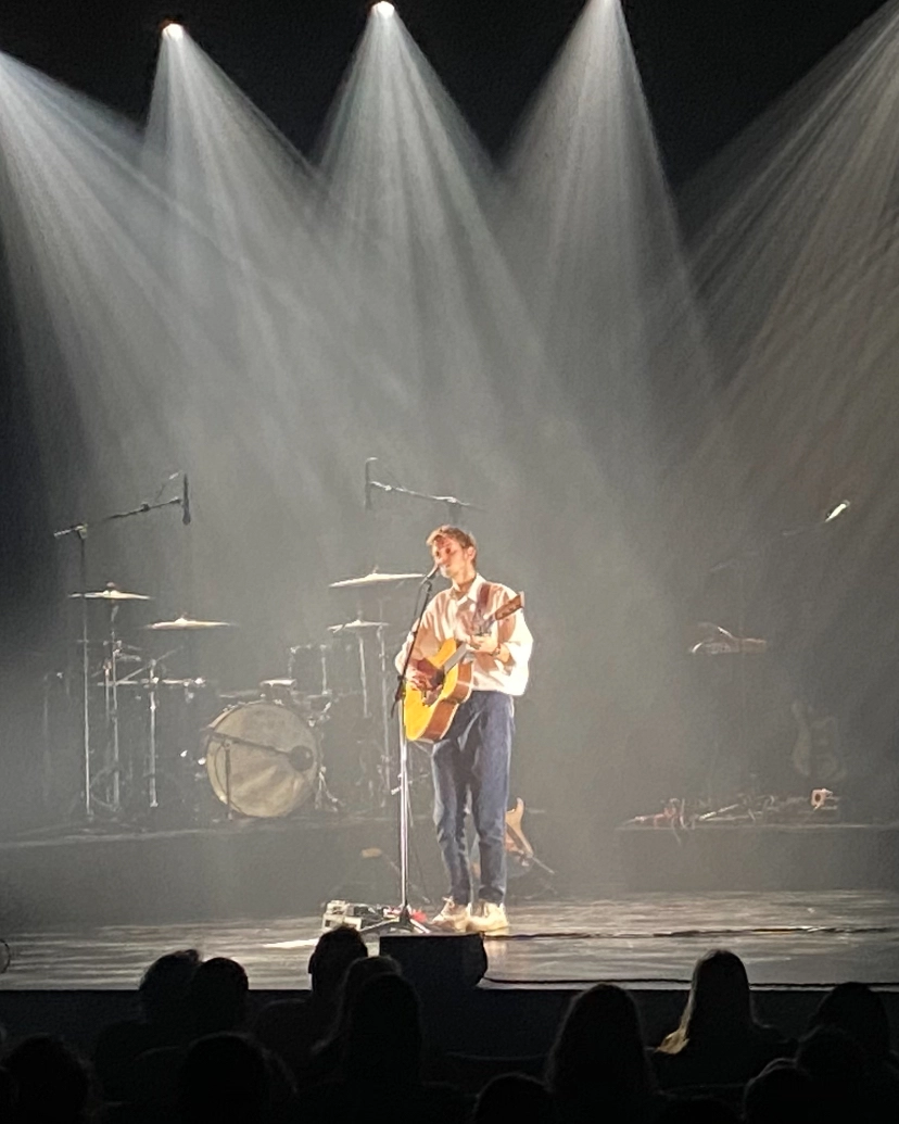 Billede af en countrysanger der står og spiller livekoncert